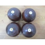 A set of four Lignum Vitae bowling woods "The Lillywhite" by Lillywhite Frowd, London, size 5 1/8