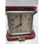 An Art Deco J.W Benson travel clock in red leather case ( case A/F)