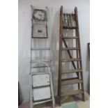 A vintage wooden step ladder along with two others