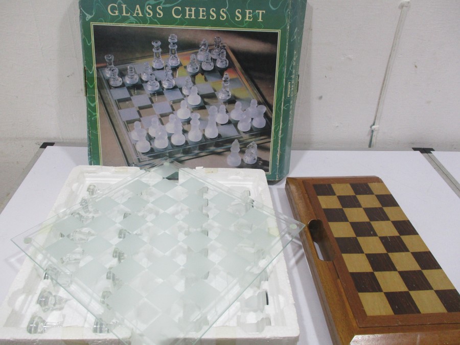 A boxed glass chess set along with one other