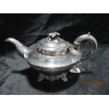 A Georgian hallmarked silver teapot with ivory insulators engraved with a foliate design, London