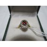 A garnet and diamond cluster ring set in 18ct gold