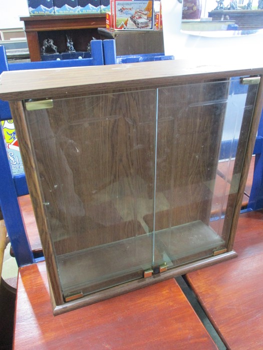 A small glass fronted display cabinet with three shelves