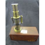 A small brass microscope in mahogany case