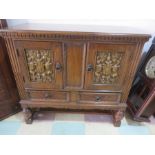 An oak carved cabinet with two drawers under