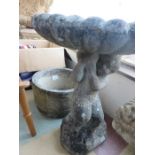 A bird bath and stone planter