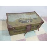 A green canvas trunk bound with leather, retailed by T Evins, Exeter, Cunard and other labels to