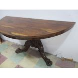 An early Victorian half moon rosewood console table on deep carved claw feet