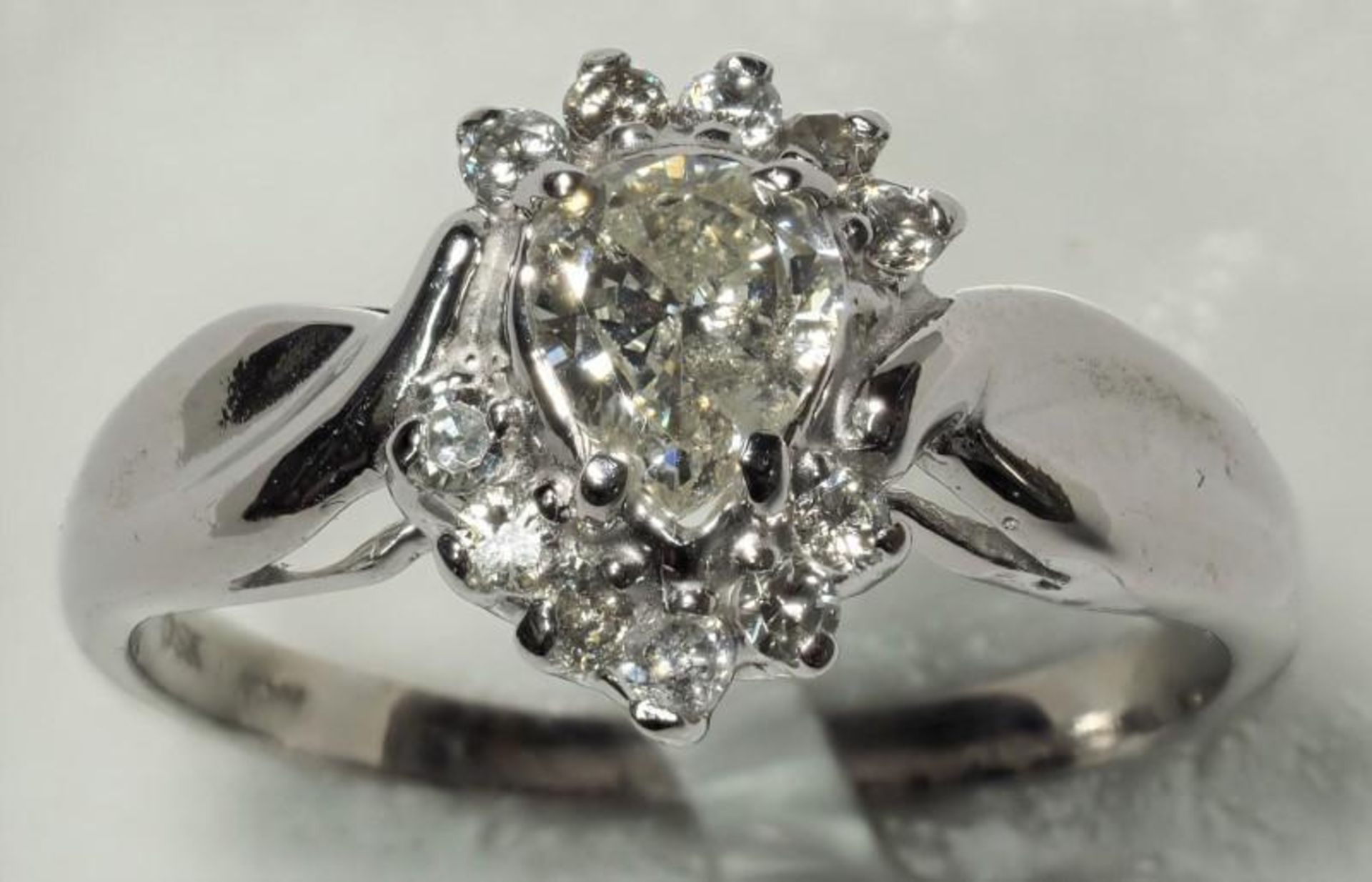 10K White Gold Pear Diamond (0.44ct, April Birthstone) with 11 Accompanying Diamonds (0.11ct) Ring.