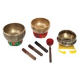 Three singing bowls with accompanying strikers and cushions, H 10 - 11,5 - ø 17 - 21 cm