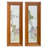 Two Chinese famille rose decorated plaques with figures in a garden, in a wooden frame, 20 x 80 cm