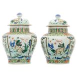 A pair of Chinese wucai overall floral decorated vases and covers with Fu lions, 17th/18thC, H 37,