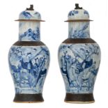 Two Chinese stoneware blue and white decorated crackleware vases and covers with deities in a