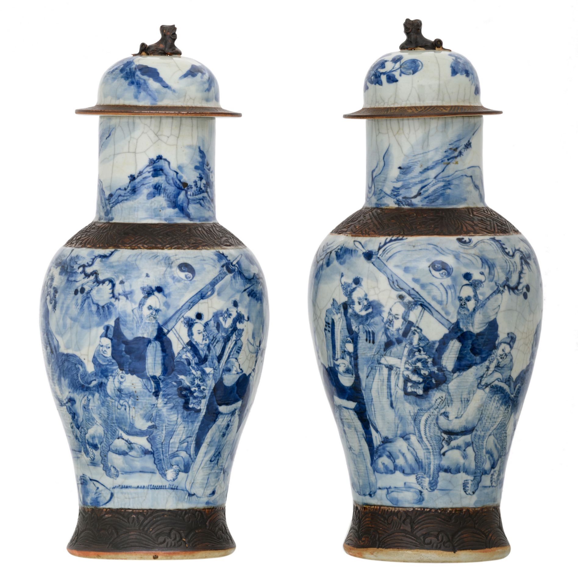 Two Chinese stoneware blue and white decorated crackleware vases and covers with deities in a