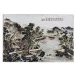 A Chinese polychrome decorated plaque with figures and boats in a mountainous river landscape,