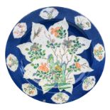A Chinese blue poudré ground plate, the roundels famille verte decorated with a rock, flower