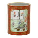 A Chinese red ground gilt decorated brush pot, the roundels famille rose decorated with animated