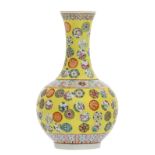 A Chinese yellow ground famille rose floral decorated bottle vase with auspicious symbols, with a