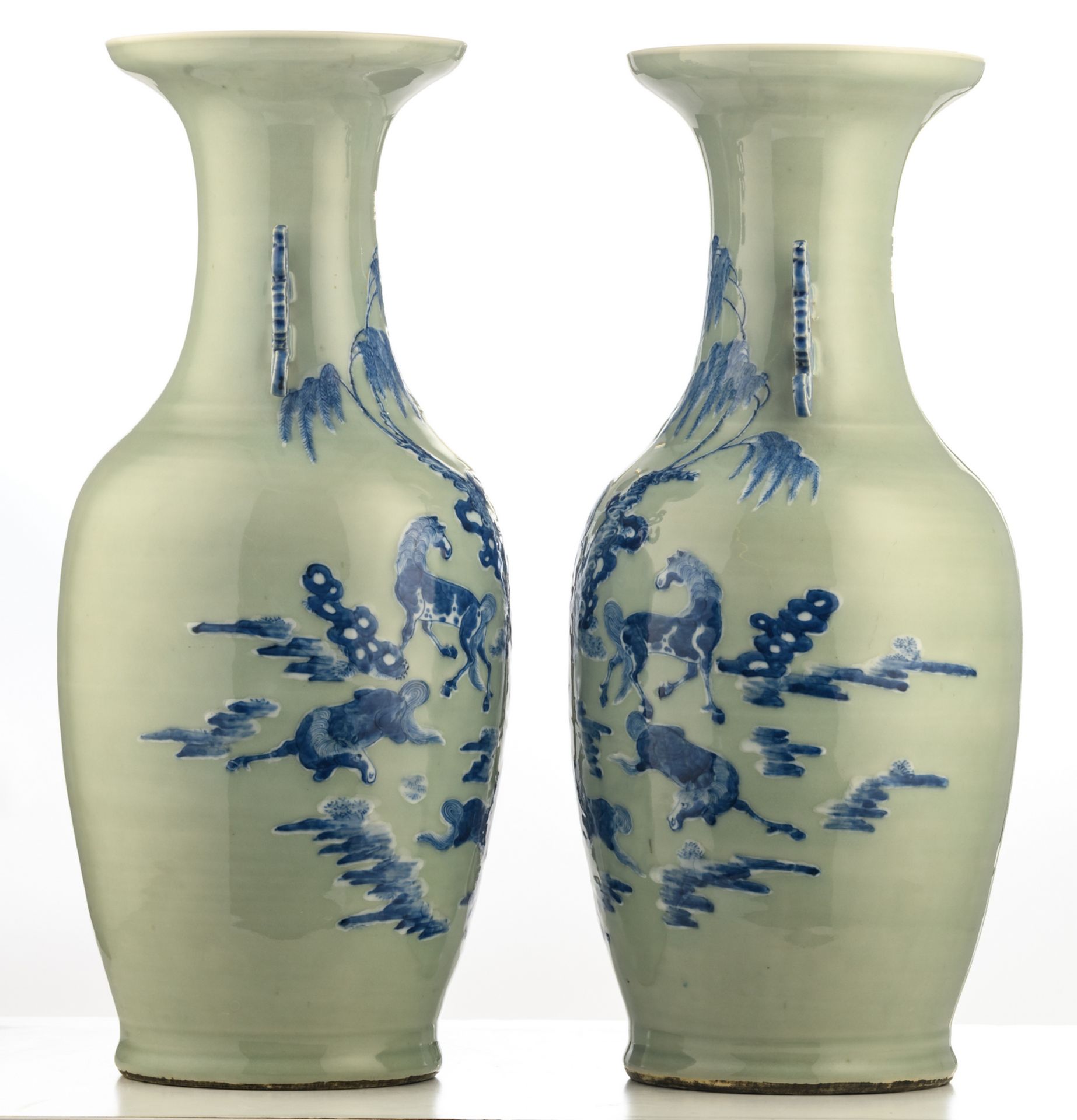 A pair of Chinese celadon ground blue and white vases, decorated with horses in a landscape, H 60 - Bild 2 aus 6