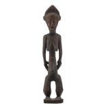 An African wooden sculpture depicting a standing female figure, possibly a blolo bla figure, Baule -