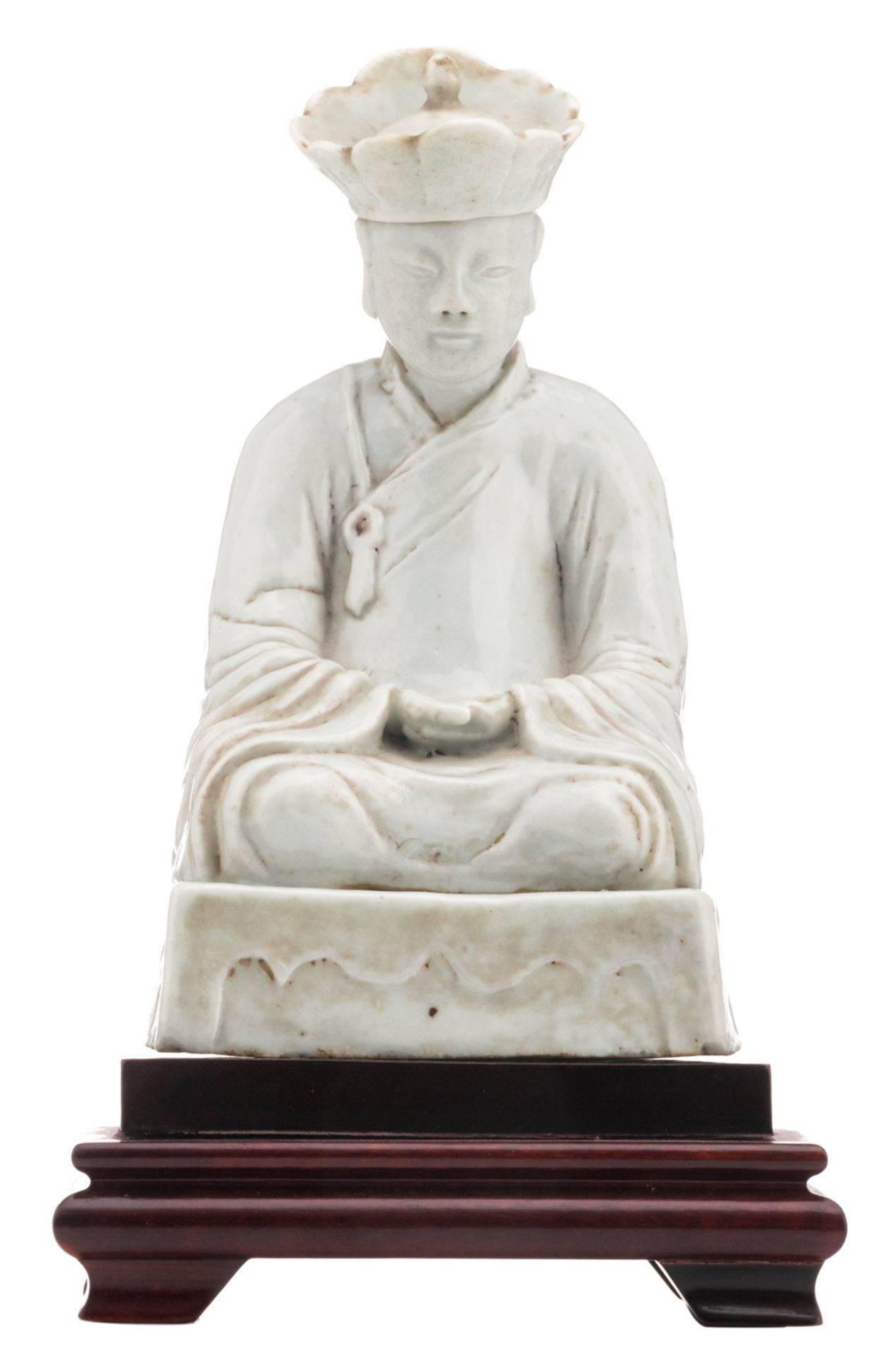 A Chinese blanc de chine figure depicting a seated monk, on a matching wooden base, 18thC, H 20,5 (