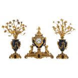 A three-piece Neoclassical patinated bronze garniture, consisting of the mantle clock decorated with