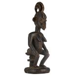 An African wooden shrine sculpture depicting a seated female figure, Igbo - Nigeria, H 55 cm