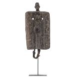 A traditional African wooden shield with on top the head of a man with a beads necklace,