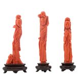 Three Chinese carved red coral sculptures depicting court ladies, on matching wooden bases, H 13,5 -