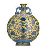 A Chinese yellow ground blue and white moon flask, decorated with scrolling lotus and peaches,