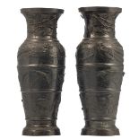 A pair of Japanese relief decorated bronze decorative items shaped as vases, overall decorated