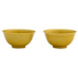 A pair of Chinese yellow glazed imperial bowls, with incised dragons on the outside, marked