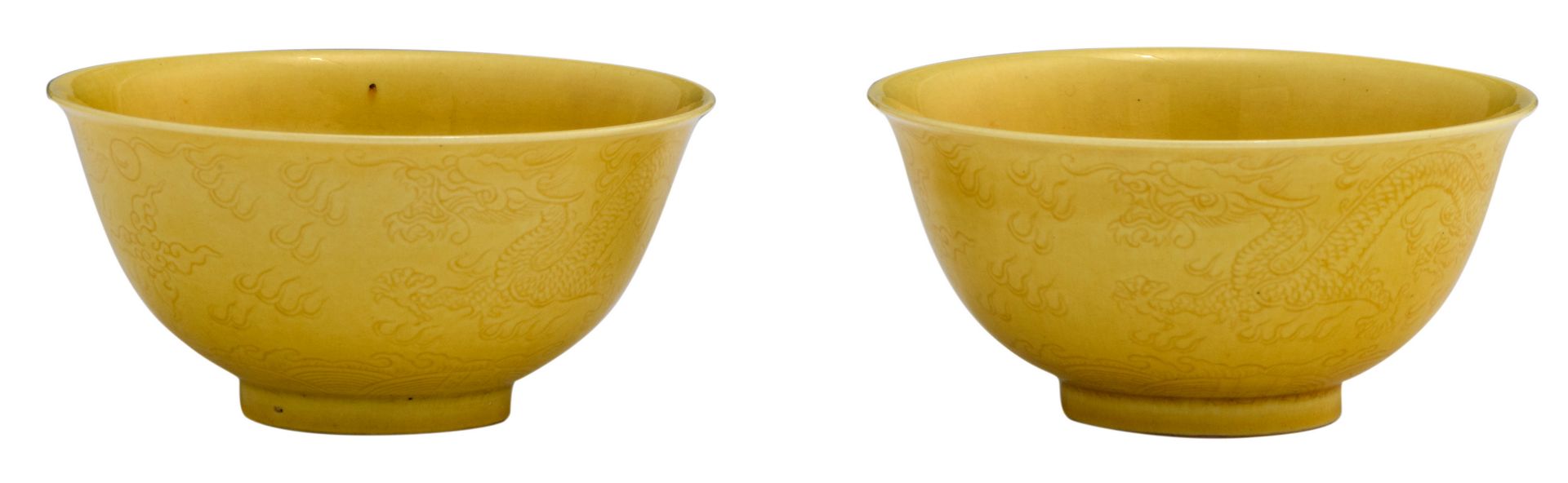 A pair of Chinese yellow glazed imperial bowls, with incised dragons on the outside, marked