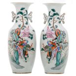 A pair of Chinese famille rose vases, decorated with figures in a cortege and calligraphic texts,