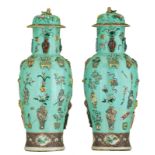 A fine pair of Chinese turquoise ground famille rose vases and covers, relief moulded with