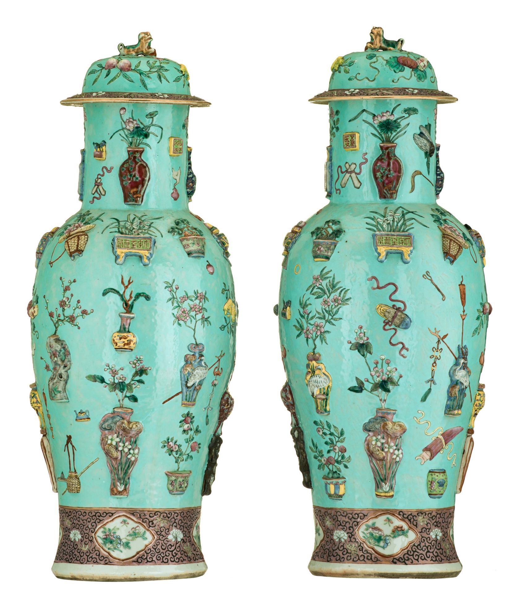 A fine pair of Chinese turquoise ground famille rose vases and covers, relief moulded with