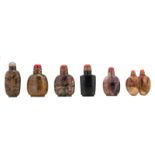 Five Chinese stone snuff bottles with semi precious stone stoppers, some with gilt bronze mount;