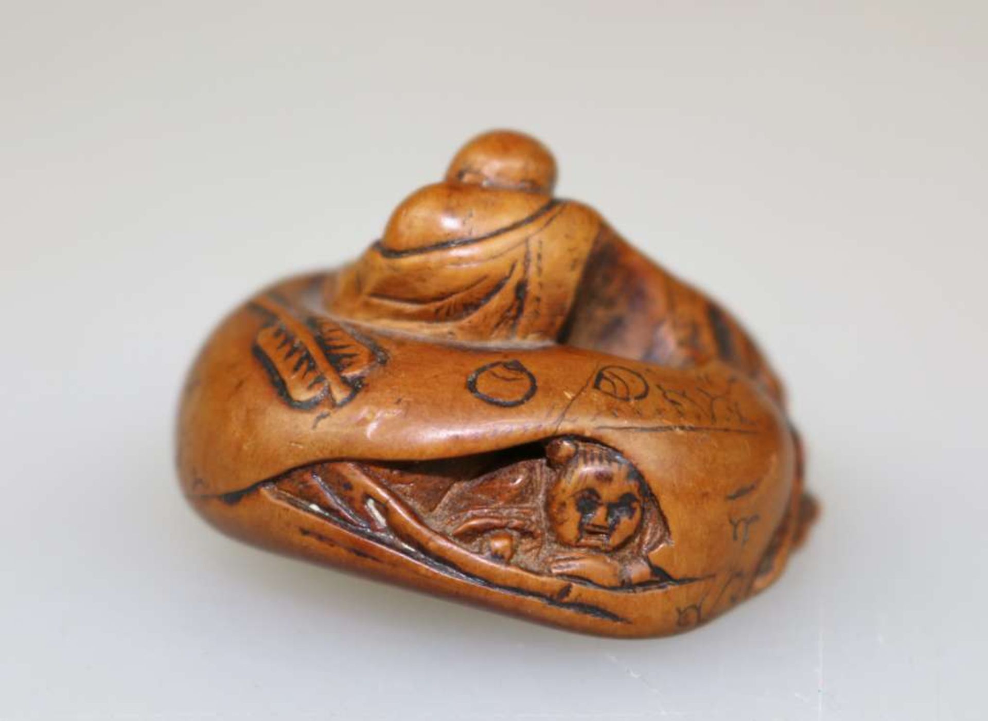 NETSUKE HOTEI UND KARAKO, Buchsbaum, 19./20. Jh. Der Glücksgott im Mantel, sein prominenter Bauch - Image 2 of 3