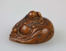 NETSUKE HOTEI UND KARAKO, Buchsbaum, 19./20. Jh. Der Glücksgott im Mantel, sein prominenter Bauch