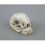 NETSUKE SCHLANGE UND SCHÄDEL, wohl Elfenbein, 19./20. Jh. Aus dem rechten Schädelauge sich