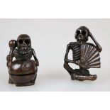 NETSUKE PAAR SKELETTIERTE FIGUREN, signiert, Holz, lasiert. H. 4,5 cm u. 5 cm.