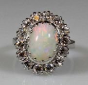 Ring, WG 585, 1 ovaler Vollopal-Cabochon, 14 Besatz-Brillanten zus. ca. 0.70 ct., 6 g, RM 16 20.00 %