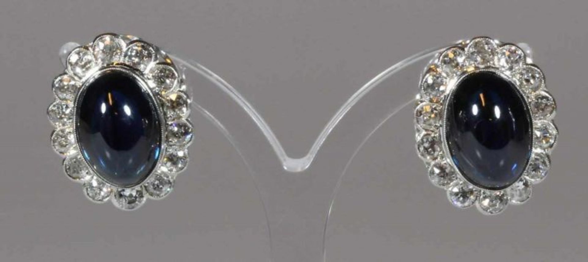 Paar Ohrclipse, WG 750, 2 Saphir-Cabochons zus. ca. 19.35 ct., 28 Altschliff-Diamanten zus. ca. 2.