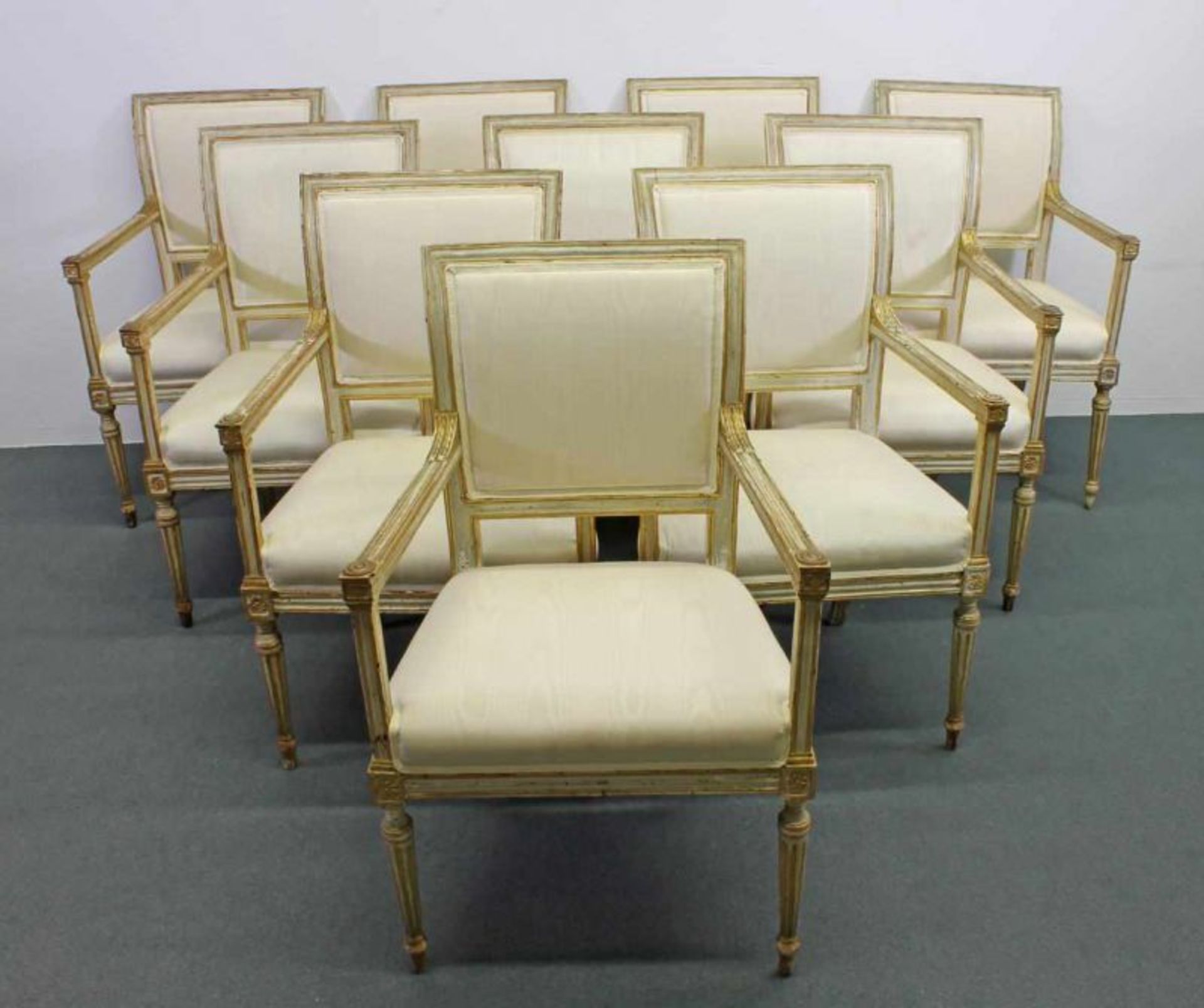 10 Armlehnstühle, Louis XVI, um 1780, creme/gold gefasst, Sitz- und Rückenpolster, erneuert,