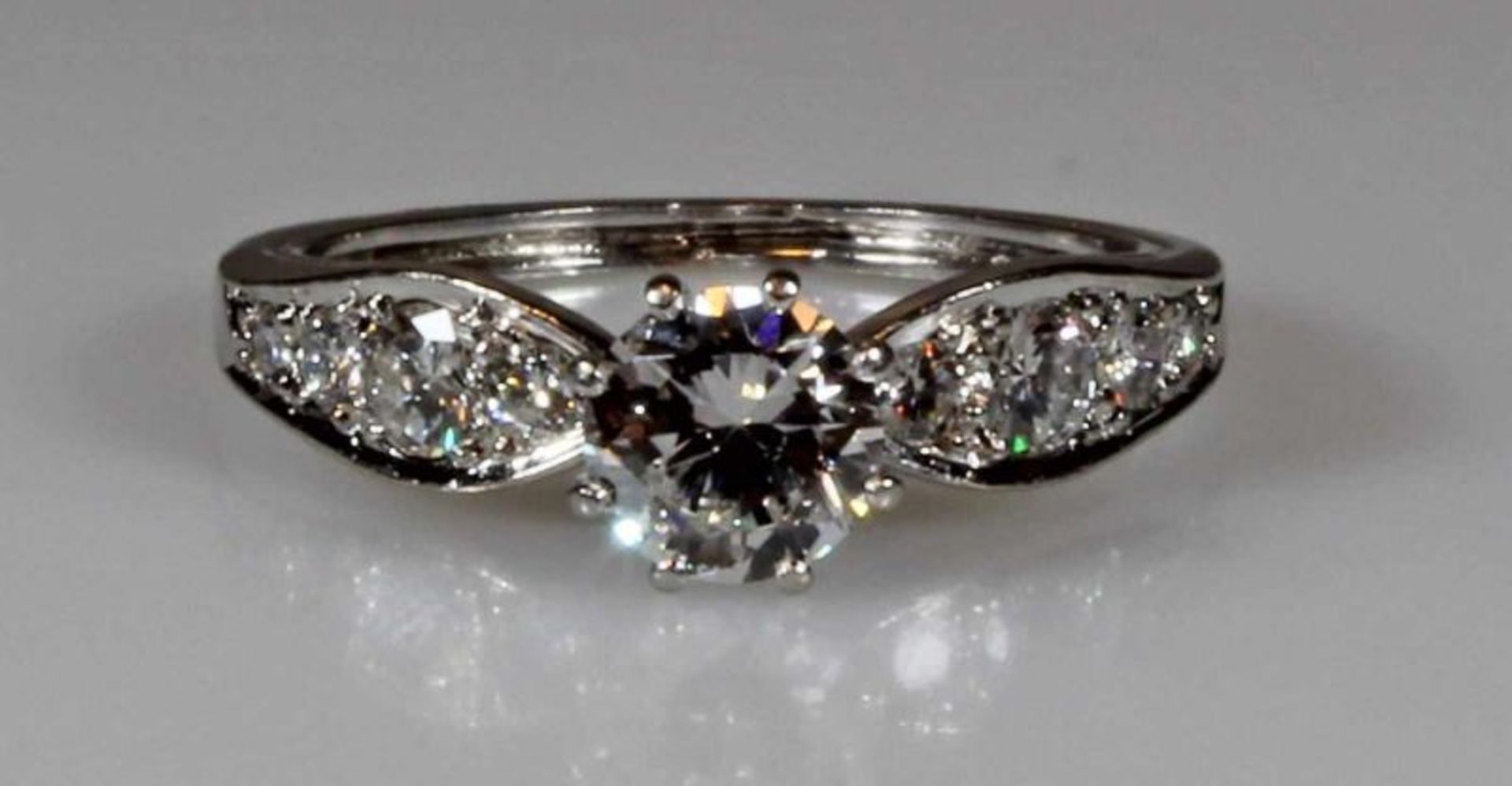 Ring, WG 750, 1 Brillant ca. 0.75 ct., etwa w/lpr.-vvs, 2 Brillanten zus. ca. 0.20 ct., etwa w/vs, 4