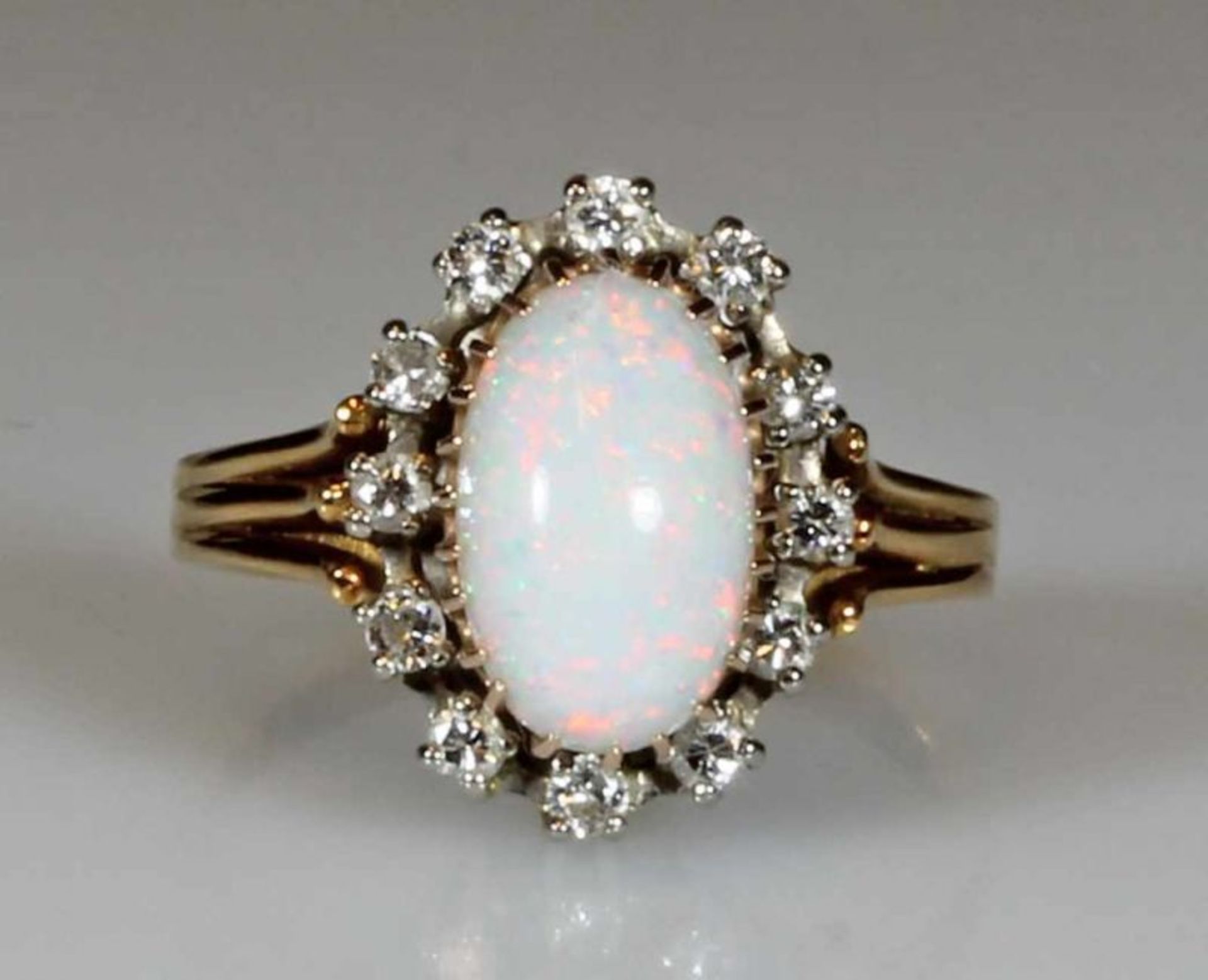 Ring, WG/RG/GG 750, 1 Opal-Cabochon, 12 Brillanten zus. ca. 0.32 ct., 5 g, RM 17.5 21.01 % buyer's