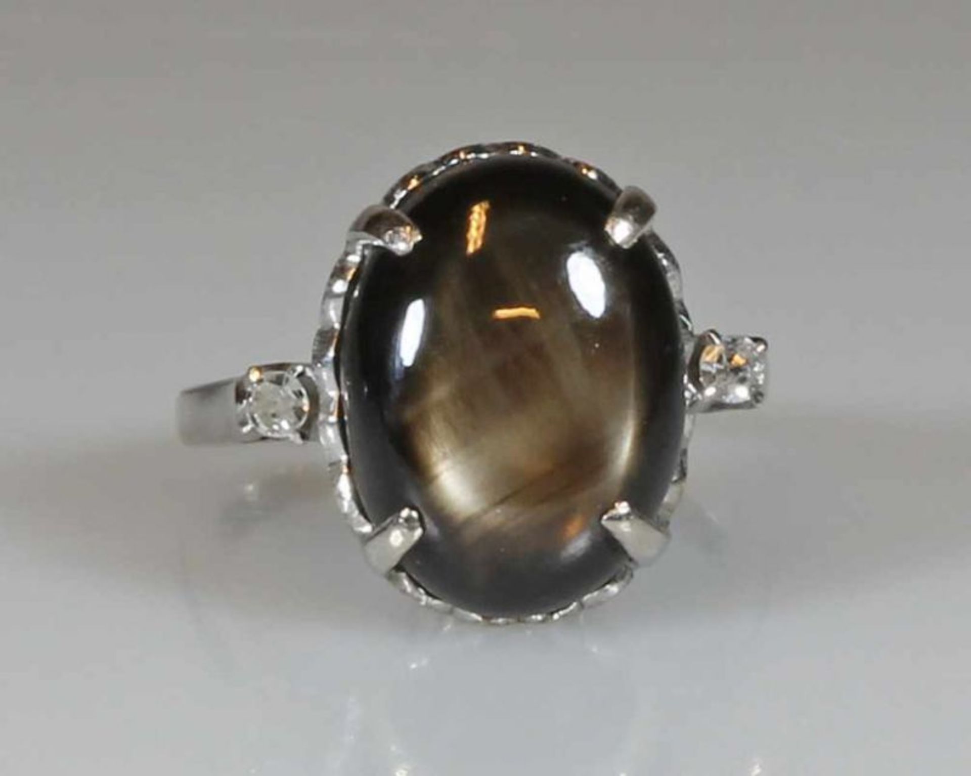 Ring, WG 333, 1 ovaler grauer Sternsaphir ca. 12.5 ct., 2 Achtkant-Diamanten zus. ca. 0.07 ct., etwa