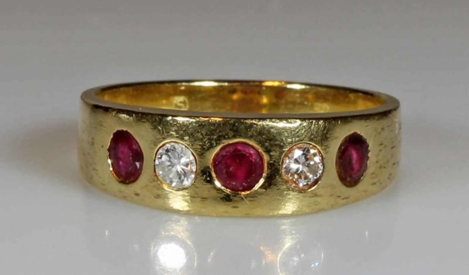 Ring, GG 750, 3 facettierte Rubine, 2 Brillanten, 6 g, RM 18.5 21.01 % buyer's premium on the hammer