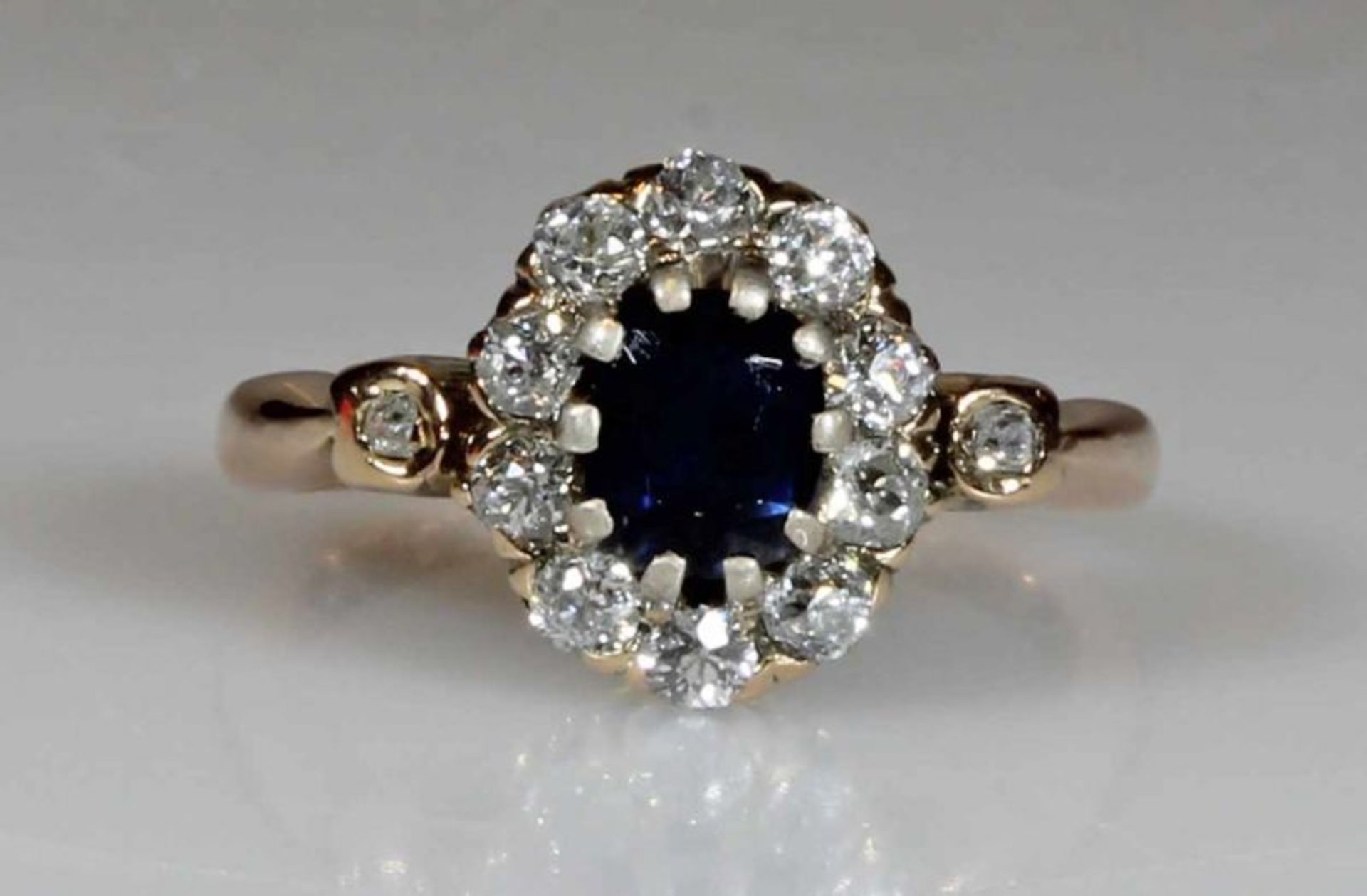 Ring, RG/WG 585, 1 ovaler facettierter Saphir, 10 Brillanten zus. ca. 0.50 ct., 2 kleine Besatz-