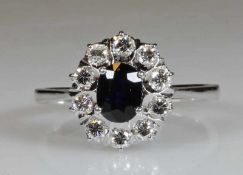 Ring, WG 750, 1 ovaler facettierter Saphir ca. 1.15 ct., 10 Brillanten zus. ca. 0.40 ct., etwa fw-